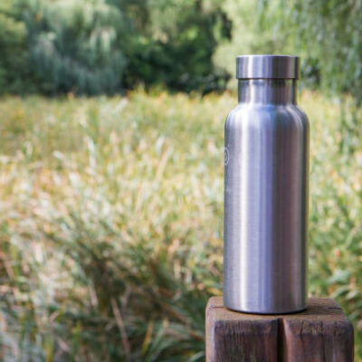 Insulated stainless steel bottle in the forest