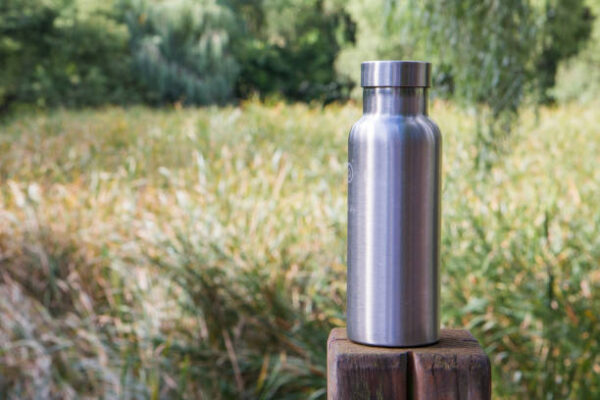 Insulated stainless steel bottle in the forest