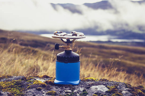 Camping stove on a rock in the mountains with rolling clouds in the background