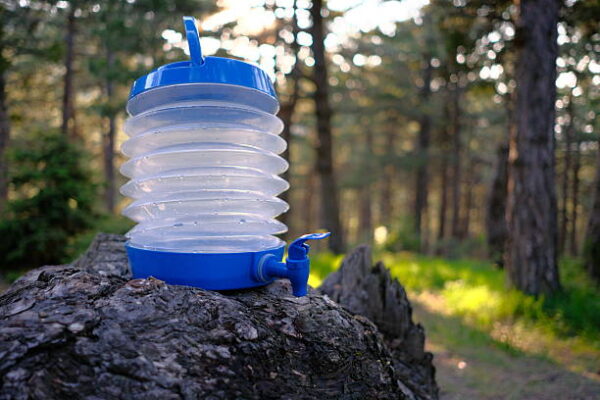 Plastic canister with blue tap in the forest